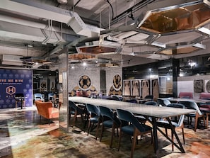 A modern conference room with a long table, blue chairs, and a decorative wall with circular patterns. - Check inn Hive (Luodong)