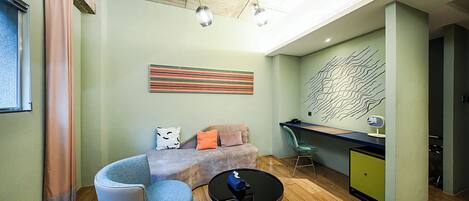 A modern living room with a sofa, a chair, a coffee table, and a desk.