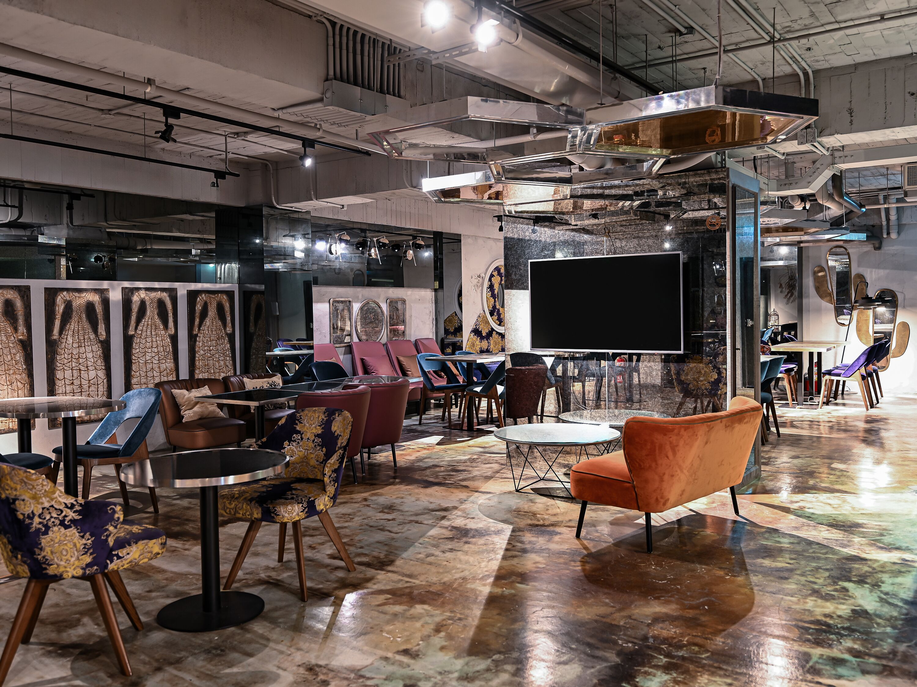 A modern interior with a large flat-screen TV, multiple seating areas, and a polished floor.