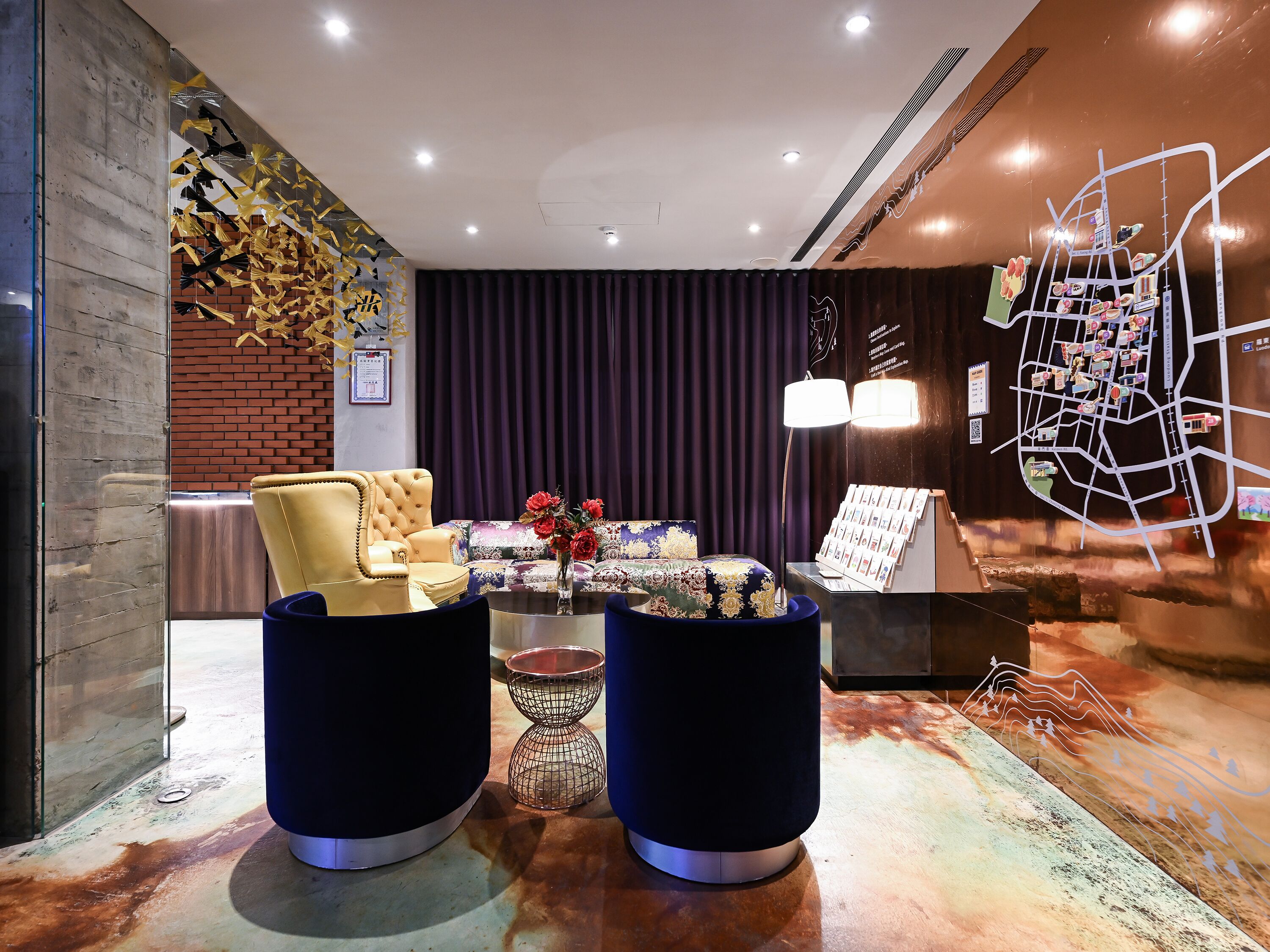 A modern lobby with a sofa, armchairs, a coffee table, and a decorative wall.