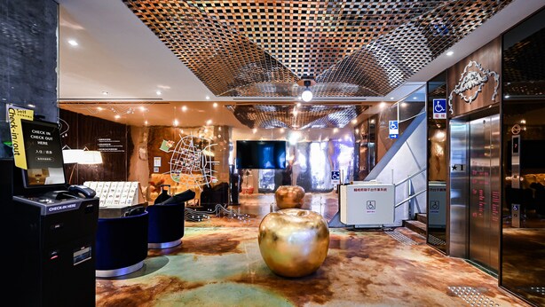 A modern lobby with a check-in kiosk, a large decorative globe, and an elevator. - Check inn Hive (Luodong)