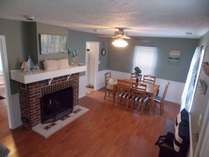 Cozy living space with a brick fireplace, dining area, and modern TV.
