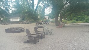 A gravel area with Adirondack chairs and a fire pit. - Beach Access! Minutes From Cedar Point, Kalahari, Jet Express, And Boat Basin! (Huron)