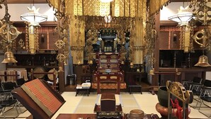 A traditional interior with ornate golden decorations, a central altar, and a seating area with a low table. - Rengeso (Tokyo)