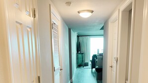 Um corredor com piso de madeira e portas brancas.