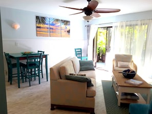 Cozy living space with a dining area, sofa, and ceiling fan.
