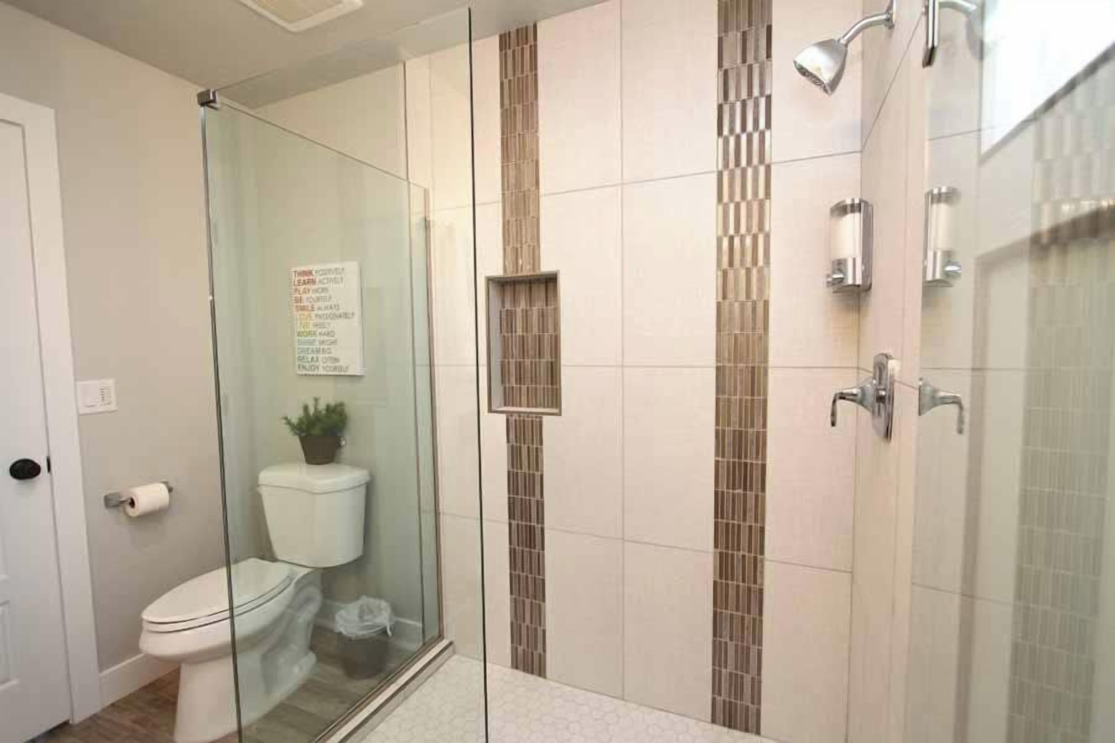Ein Badezimmer mit Duschkabine, Toilette und Waschbecken.