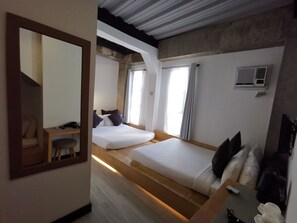Ein Hotelzimmer mit zwei Betten, einem Schreibtisch und einem Stuhl.
