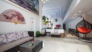 Un interior moderno con un sofá, una silla colgante y una zona de comedor.