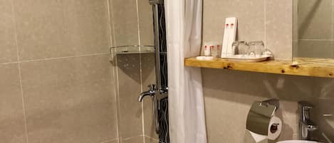 A bathroom with a shower, toilet, and sink.