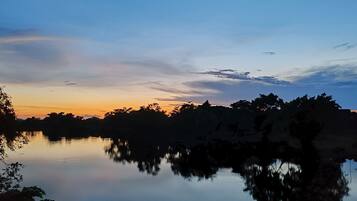 Un lago tranquilo al atardecer, con árboles reflejándose en el agua.
