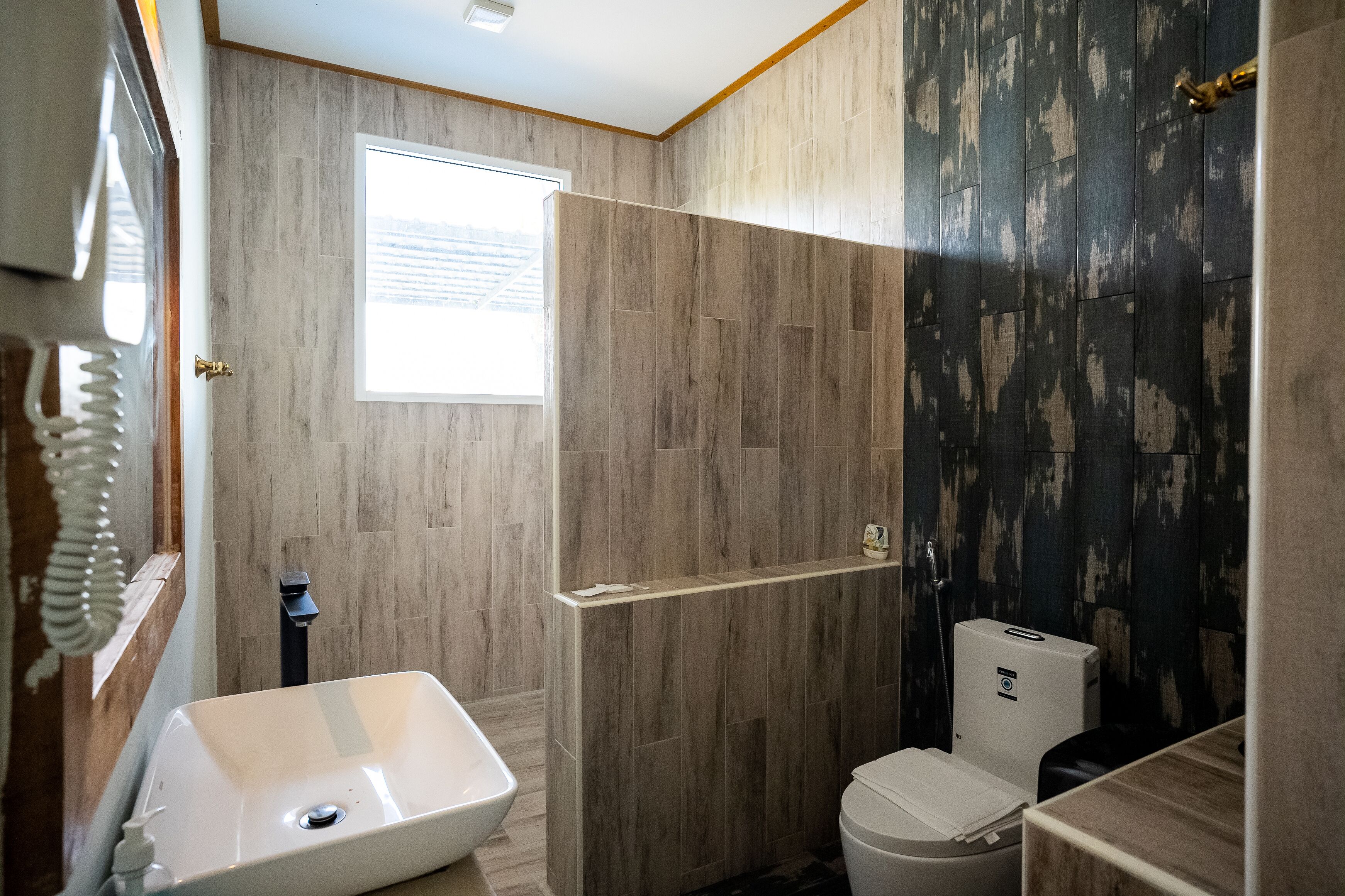 A bathroom with a white sink, a toilet, and a shower area.
