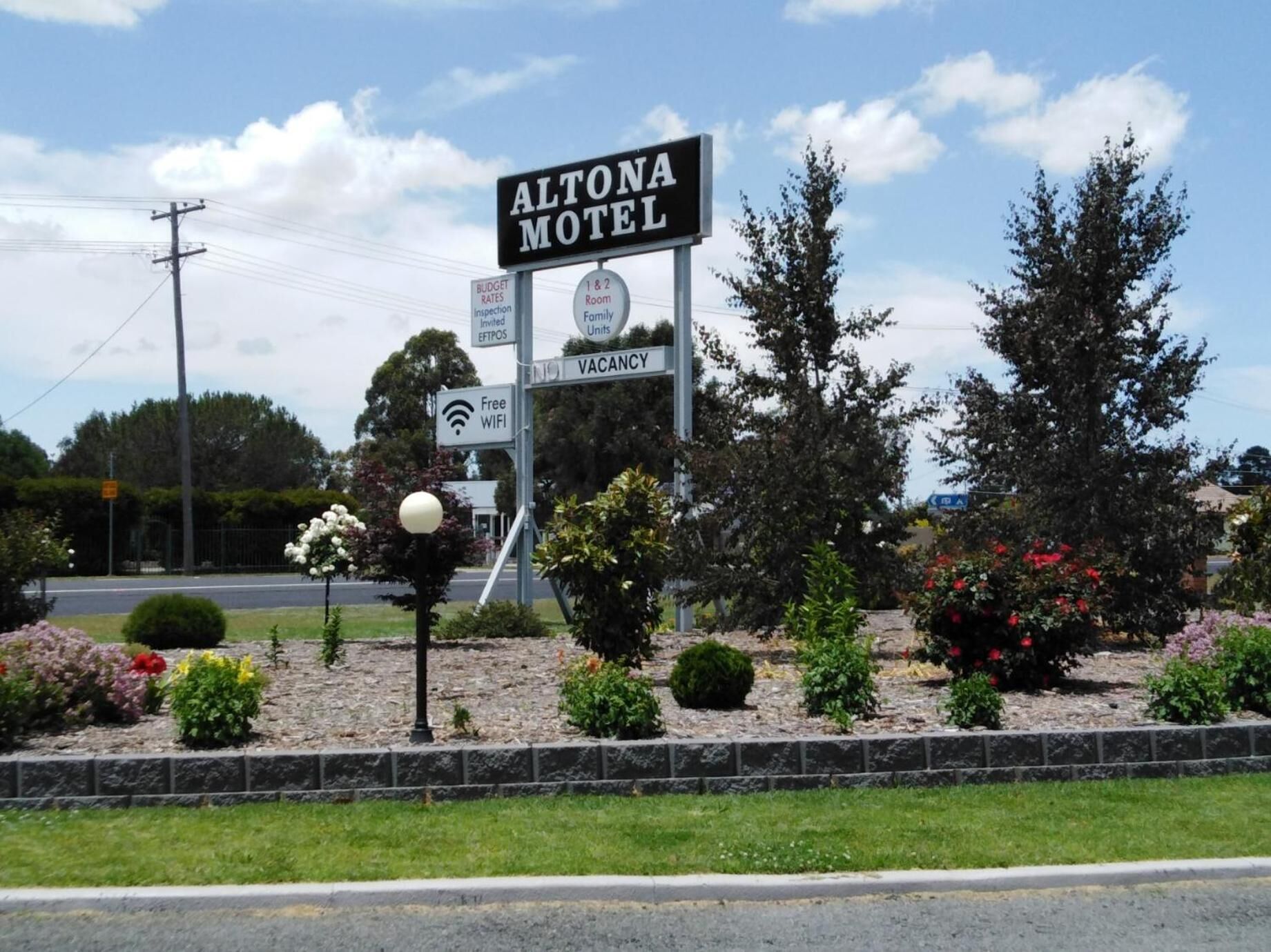 Schild des Altona Motel mit Annehmlichkeiten wie kostenlosem WLAN, günstigen Preisen, Inspektion und Familienzimmern (1 und 2 Zimmer).
