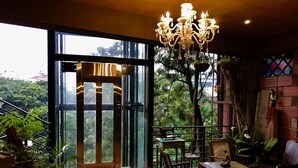 Un'ampia stanza con una grande finestra, un lampadario e vista sull'esterno.