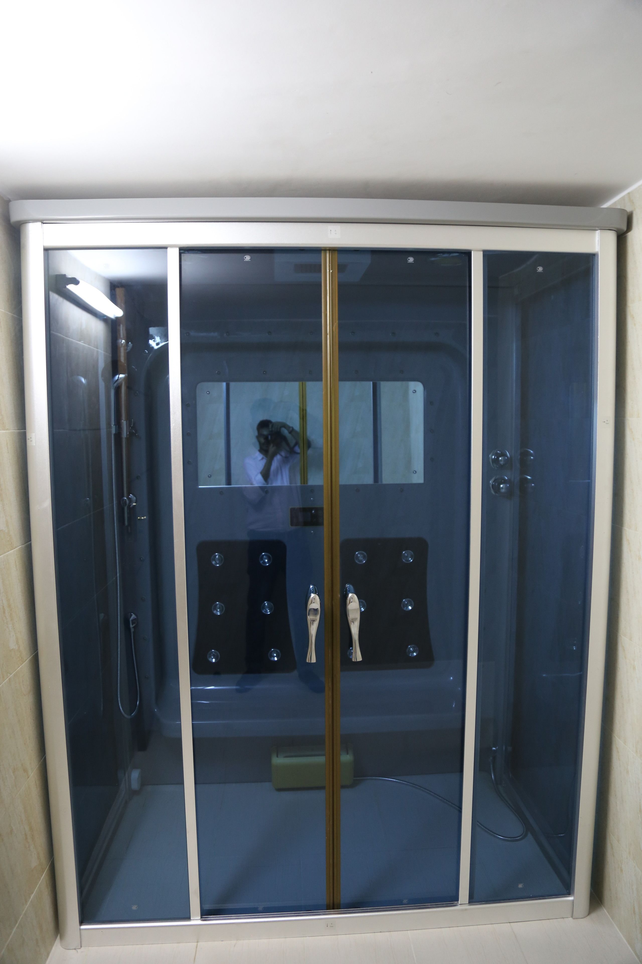 A walk-in shower with a glass door, a bench inside, and a mirror on the wall.