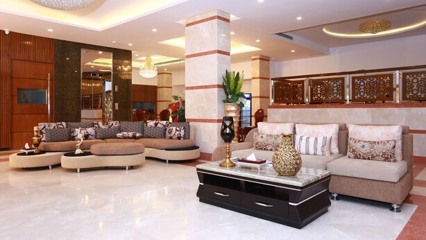 A spacious lobby with a large sectional sofa, a coffee table, and a decorative vase. - Marino Royal Hotel (Dhaka)