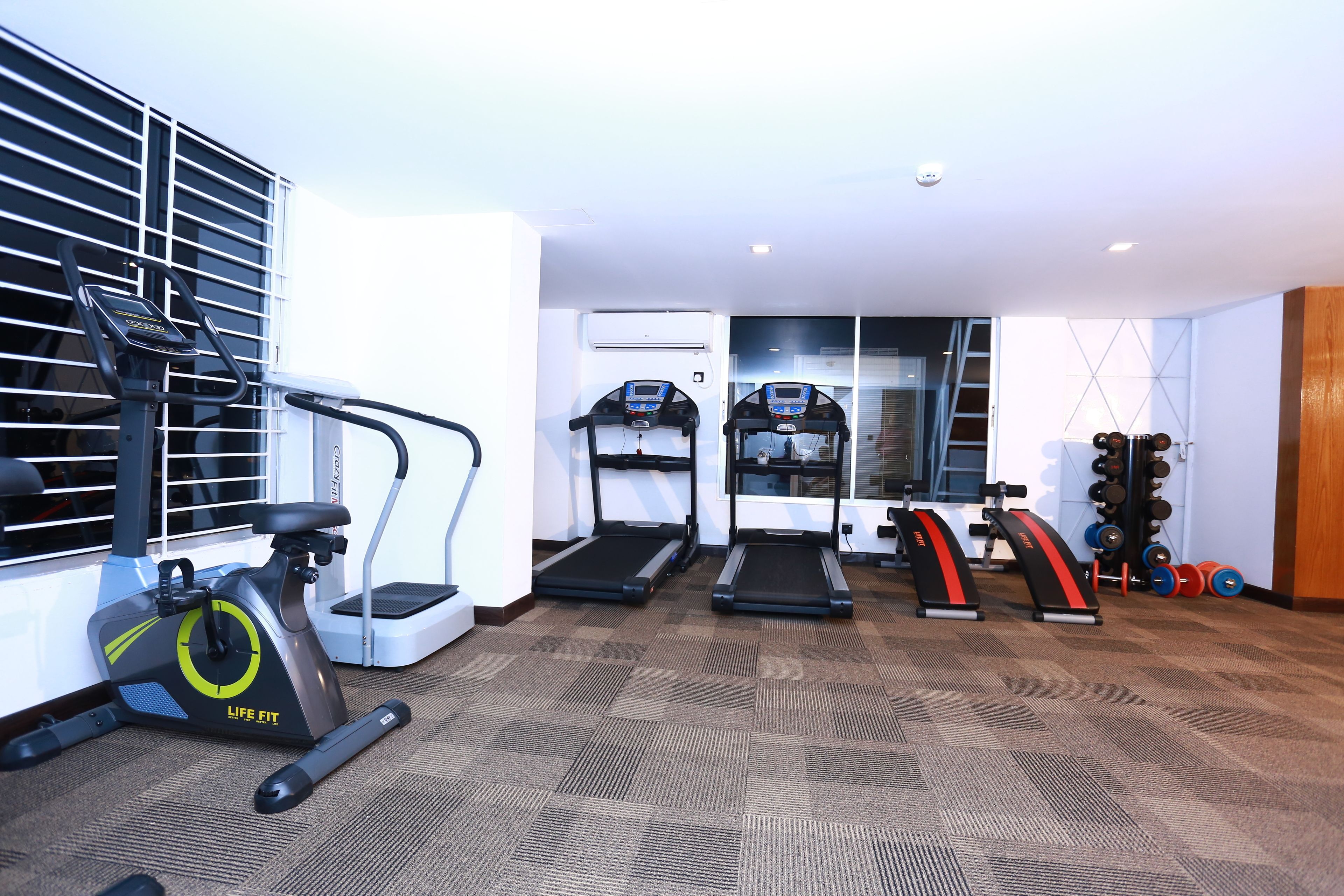 A gym with treadmills, an elliptical, and weightlifting equipment.