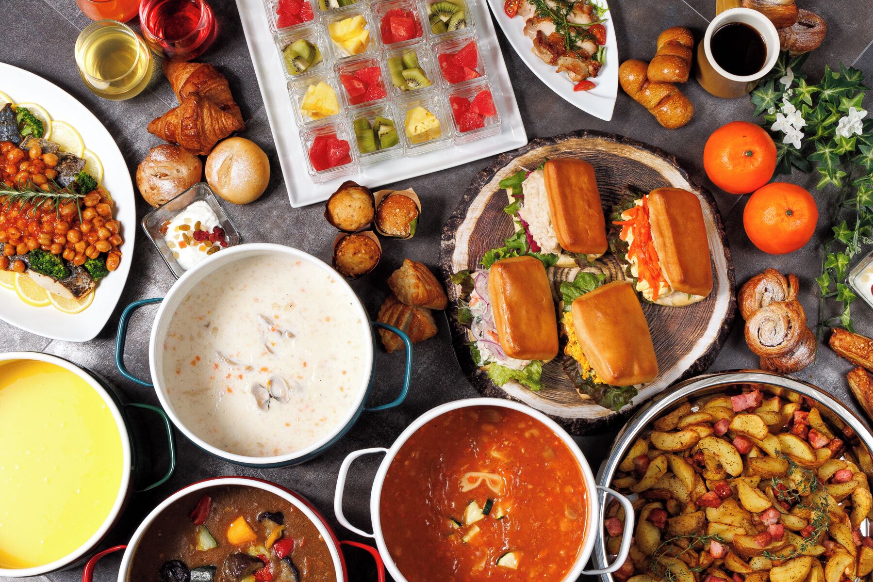 Un assortiment de plats comprenant une soupe, des sandwichs et un plateau de fruits.