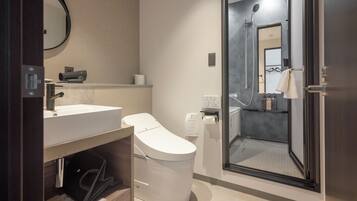 Un baño moderno con inodoro, lavabo y ducha.