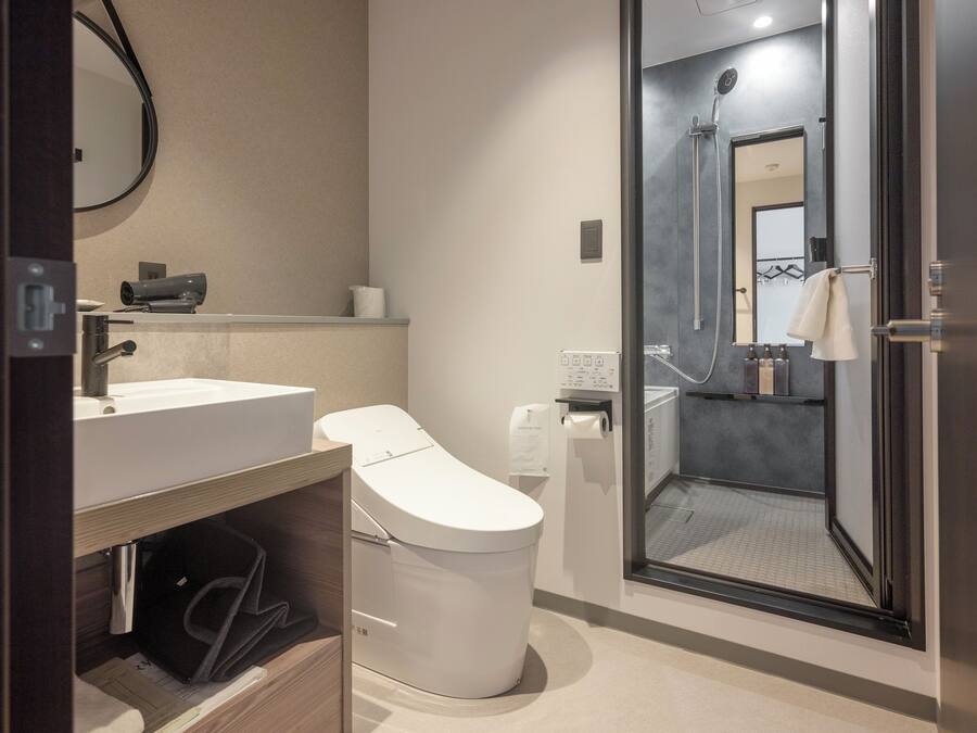 Un baño moderno con inodoro, lavabo y ducha.