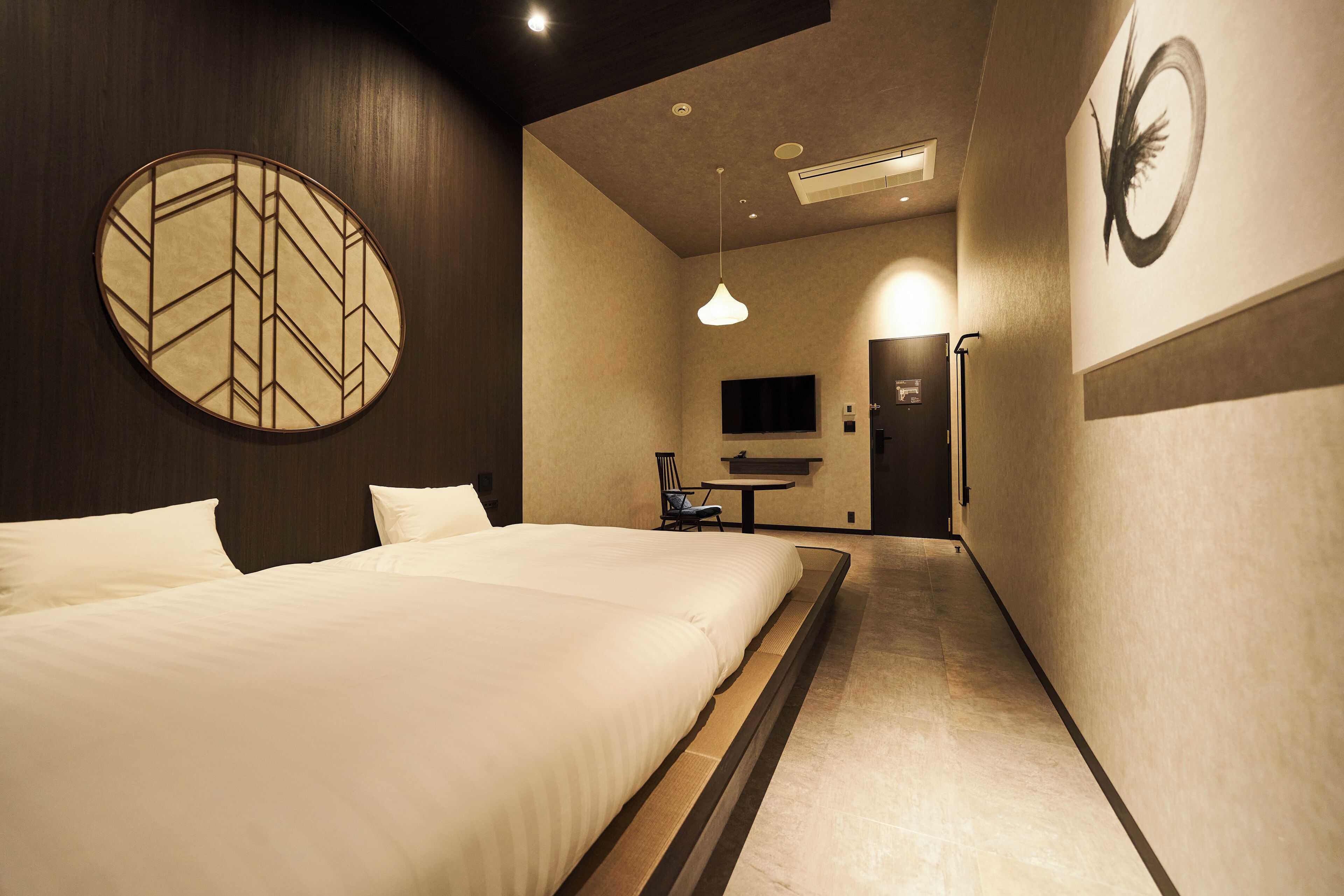 A hotel room with a large bed, a television, and a desk with a chair.