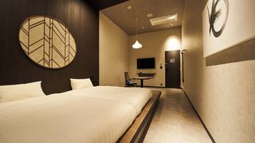 A hotel room with a large bed, a television, and a desk with a chair.