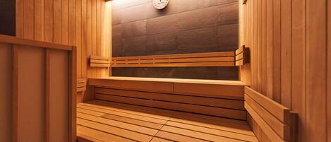 A sauna with wooden benches and a clock on the wall.