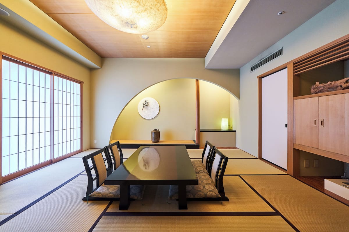 A traditional Japanese room with tatami flooring, a low table, and shoji screens.