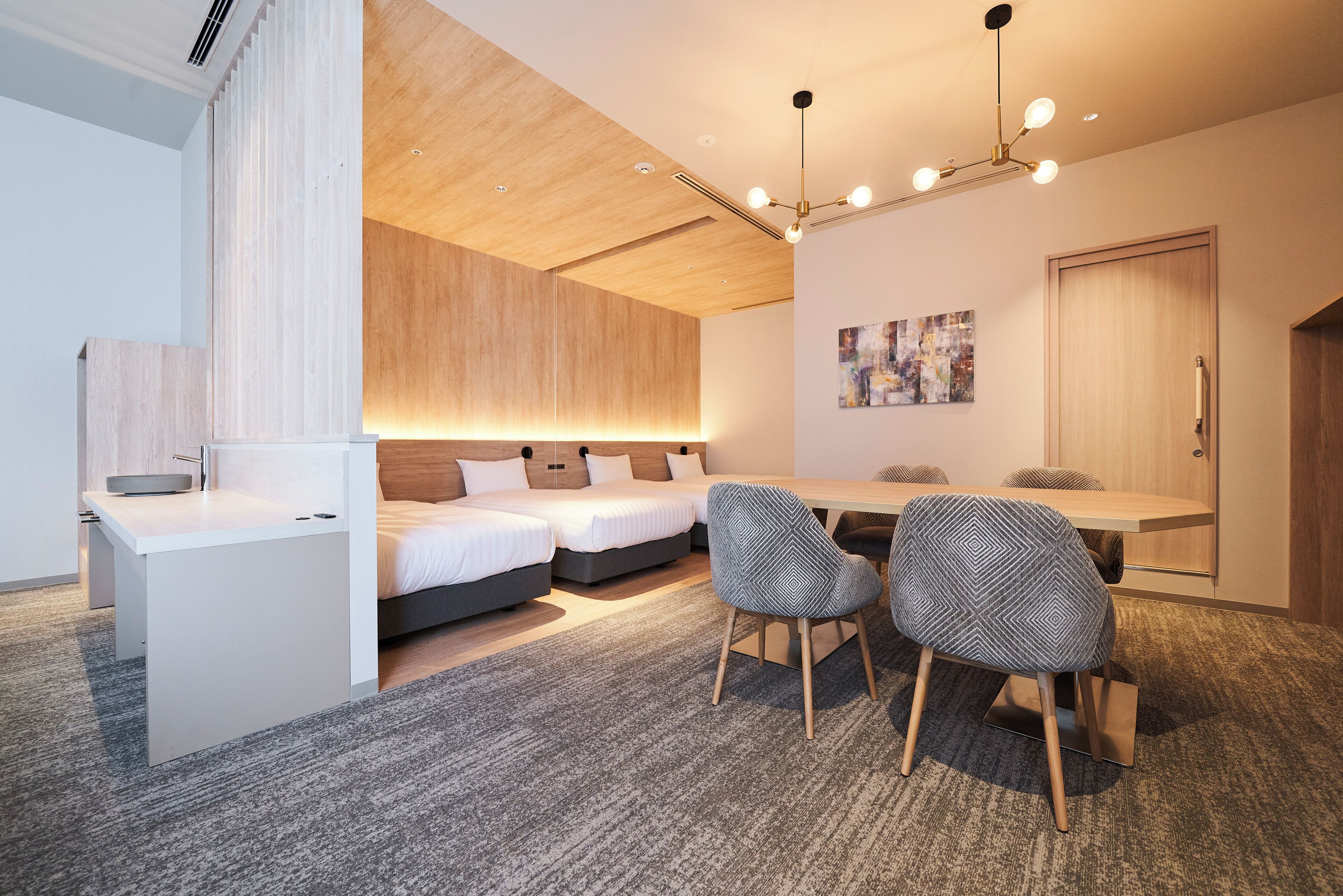 Una habitación de hotel moderna con una cama, un escritorio y una zona de comedor.
