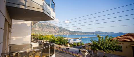 A balcony with a view of the sea and mountains.