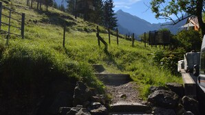 A stone staircase leading up a grassy hill with a mountain in the background. - Bergsteiger-Hotel Grüner Hut (Bad Hindelang)