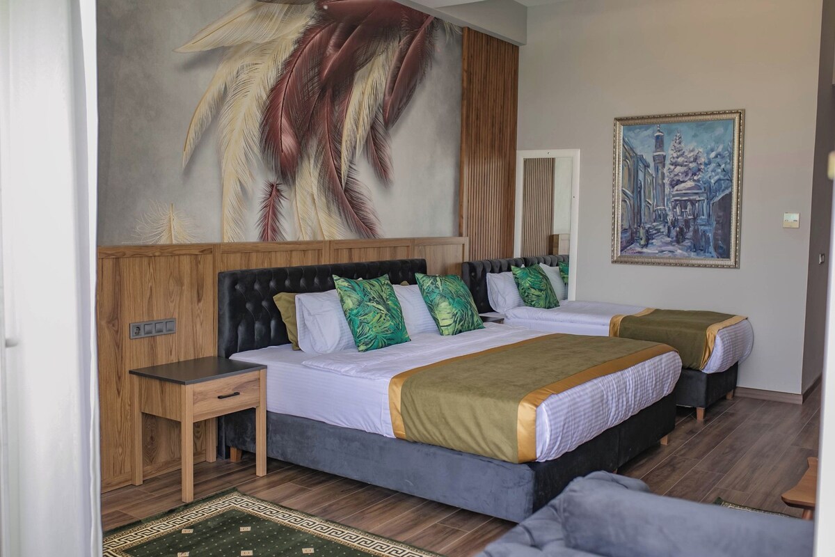 Et hotelværelse med et stort mural, to senge, et natbord og en træsenggavl.