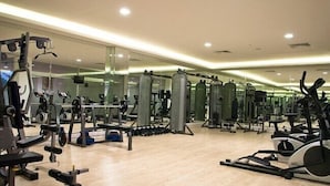 A gym with various exercise equipment, mirrors, and a wooden floor. - The Green Oasis Otel & Spa (Yalova)