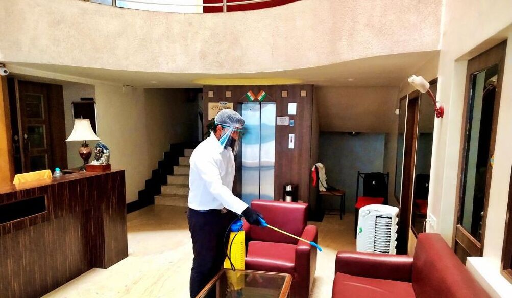 A person cleaning a lobby area with a mop and bucket.