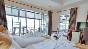 A hotel room with two beds, each adorned with white towels and swan-shaped bathrobes. - Fah Talay Resort (Rayong)