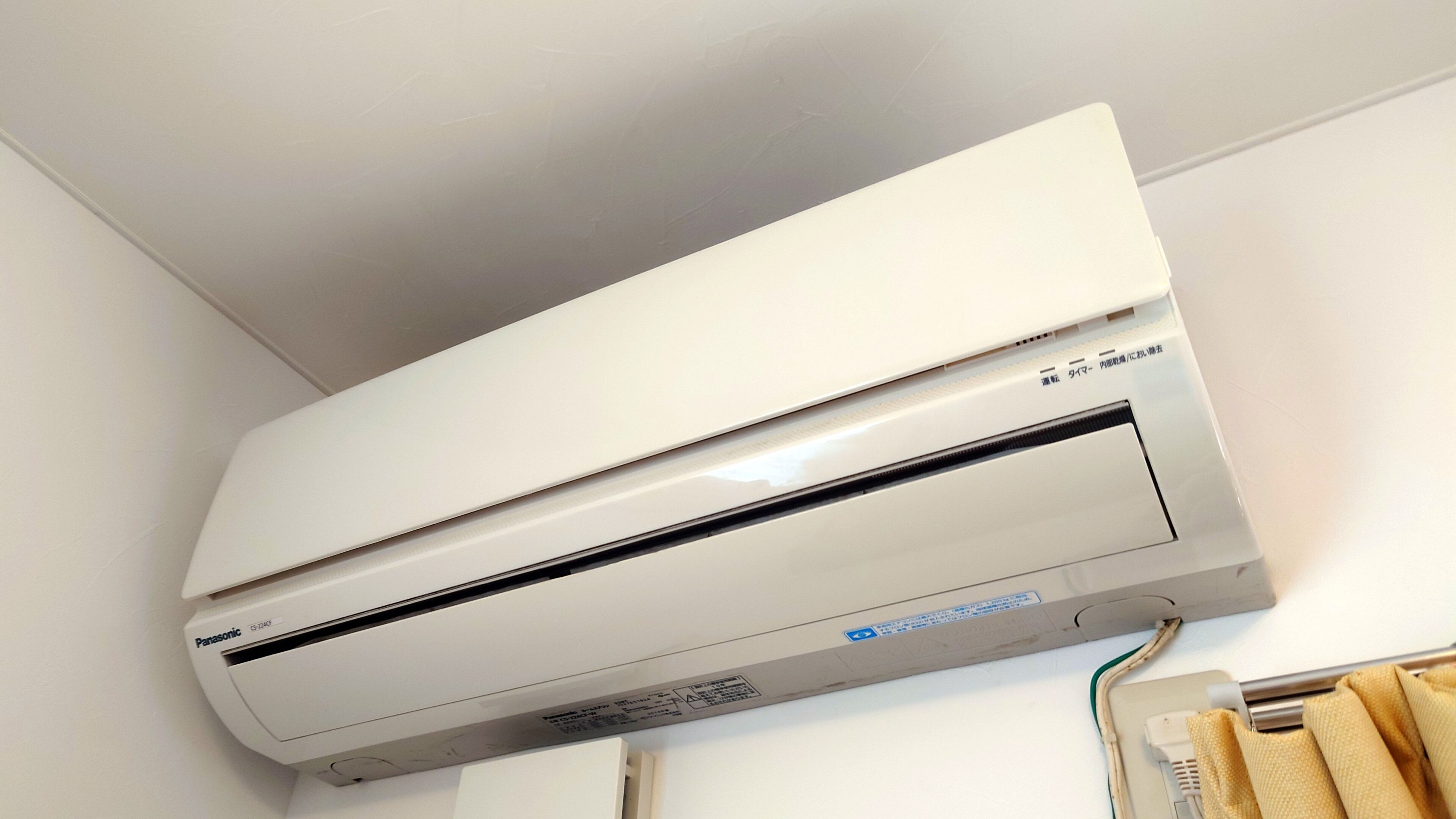 A white Panasonic air conditioner mounted on a wall.