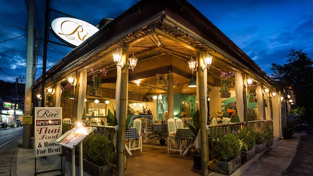 A restaurant with a signboard indicating it offers Thai food and rooms for rent. - Rice Restaurant & Rooms (Karon)