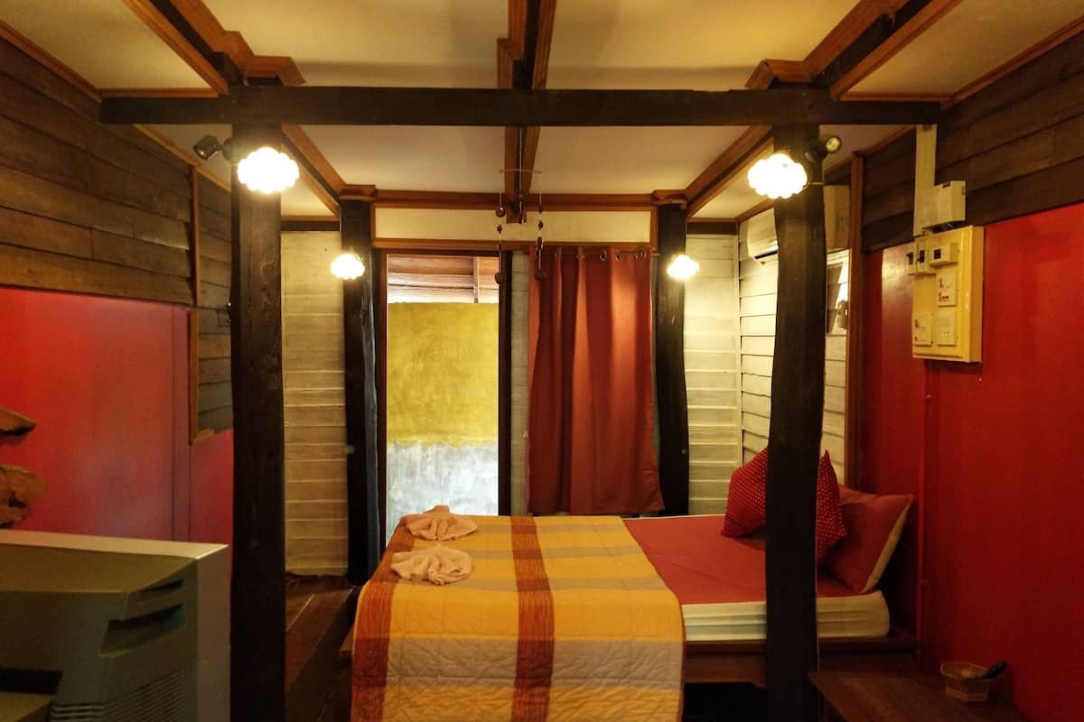 A room with a bed, a desk, and a window with curtains.