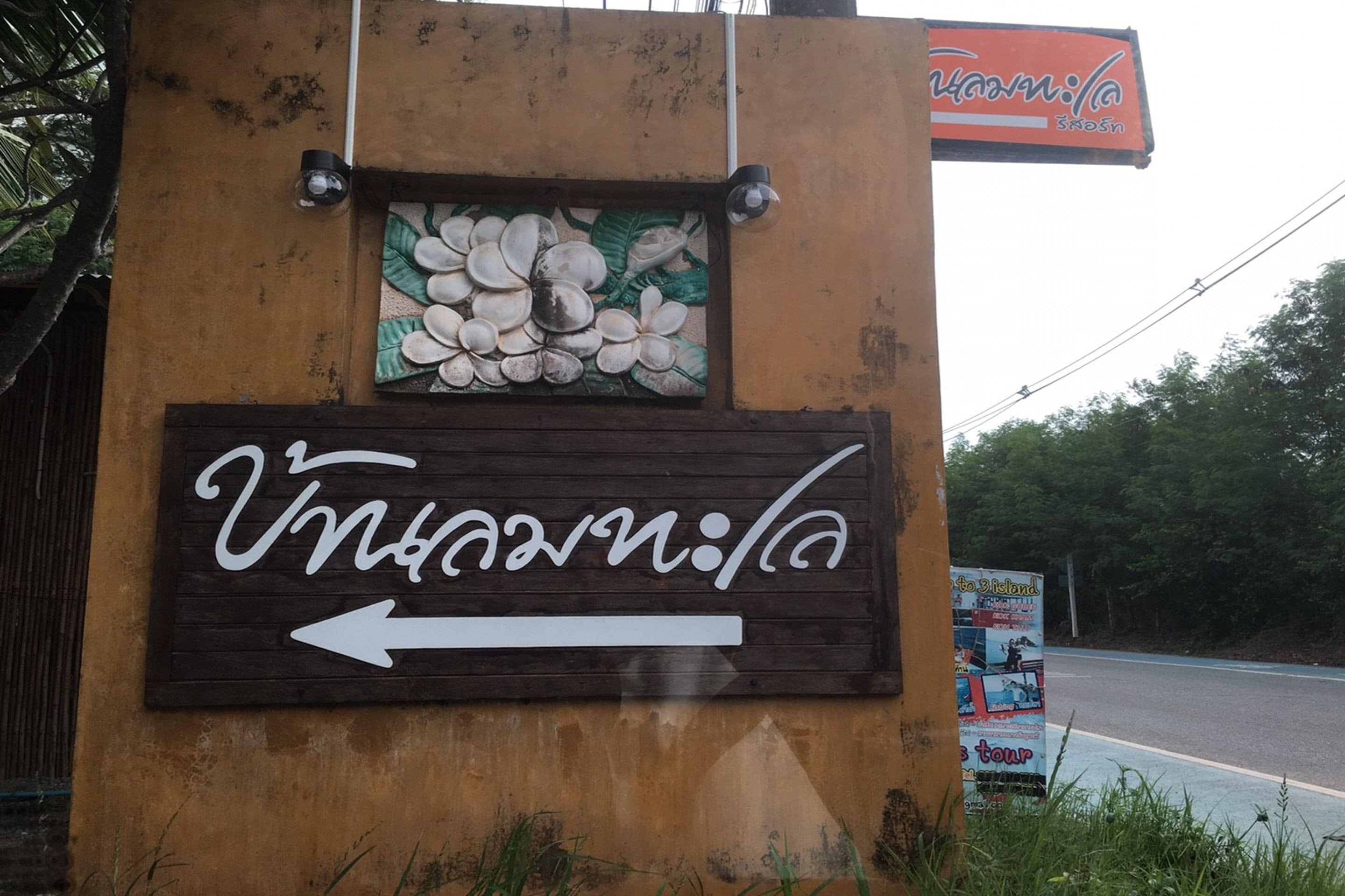 A wooden sign with a white arrow pointing left, indicating a direction.