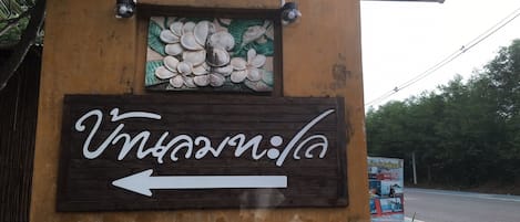A wooden sign with a white arrow pointing left, indicating a direction.