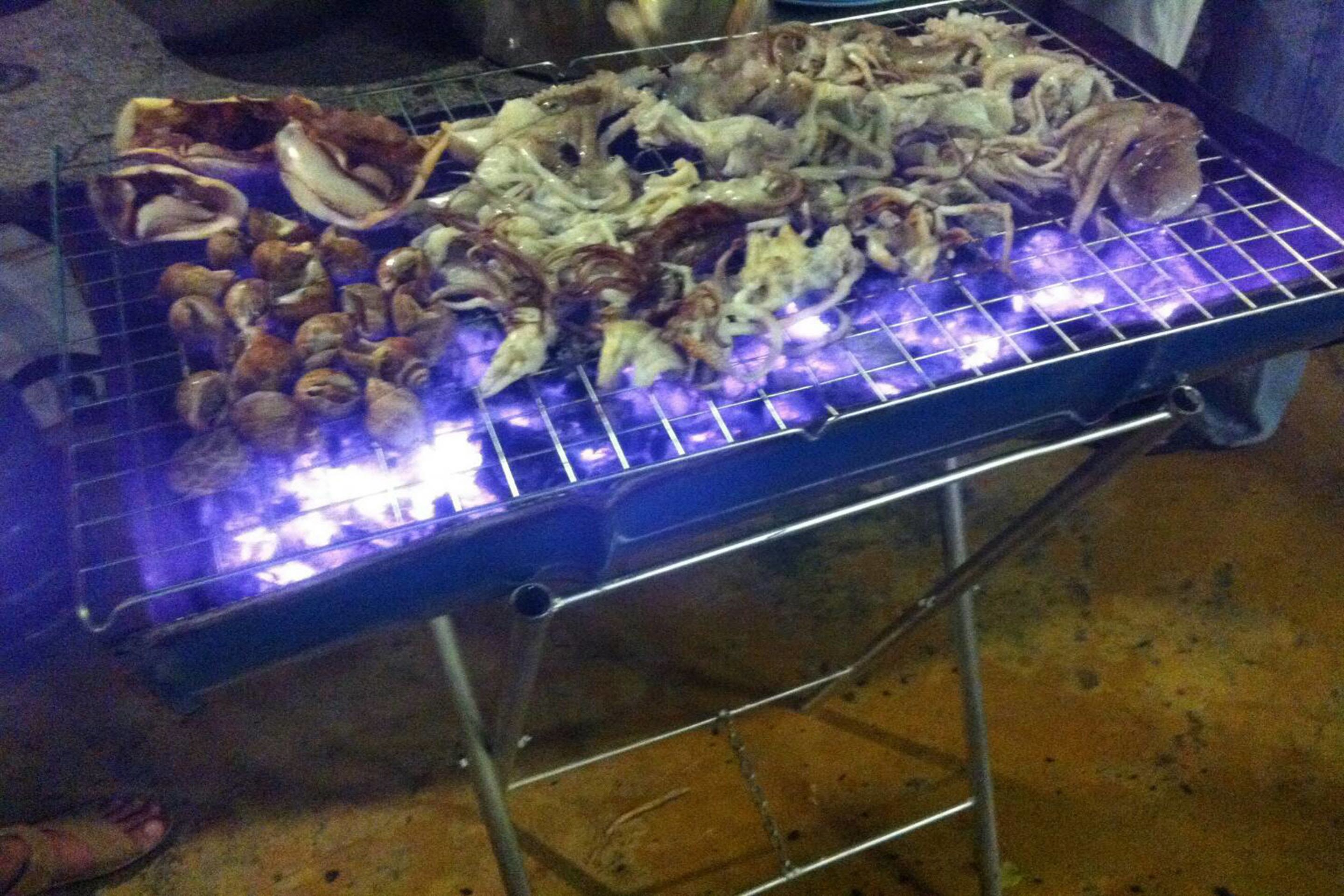 Een barbecue met verschillende soorten zeevruchten die worden bereid.