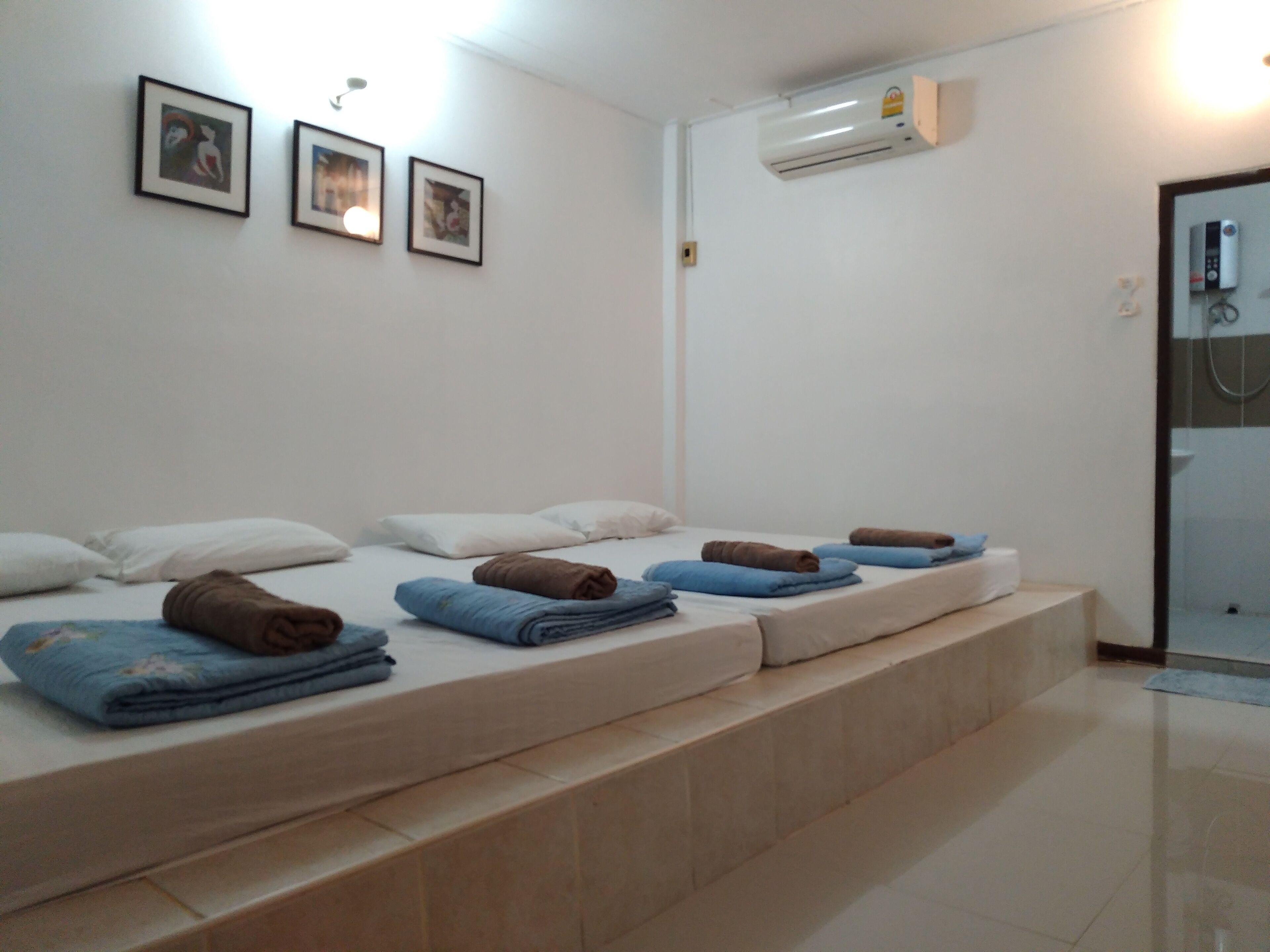 Een hotelkamer met een bed, een douche en een wandgemonteerde airconditioner.