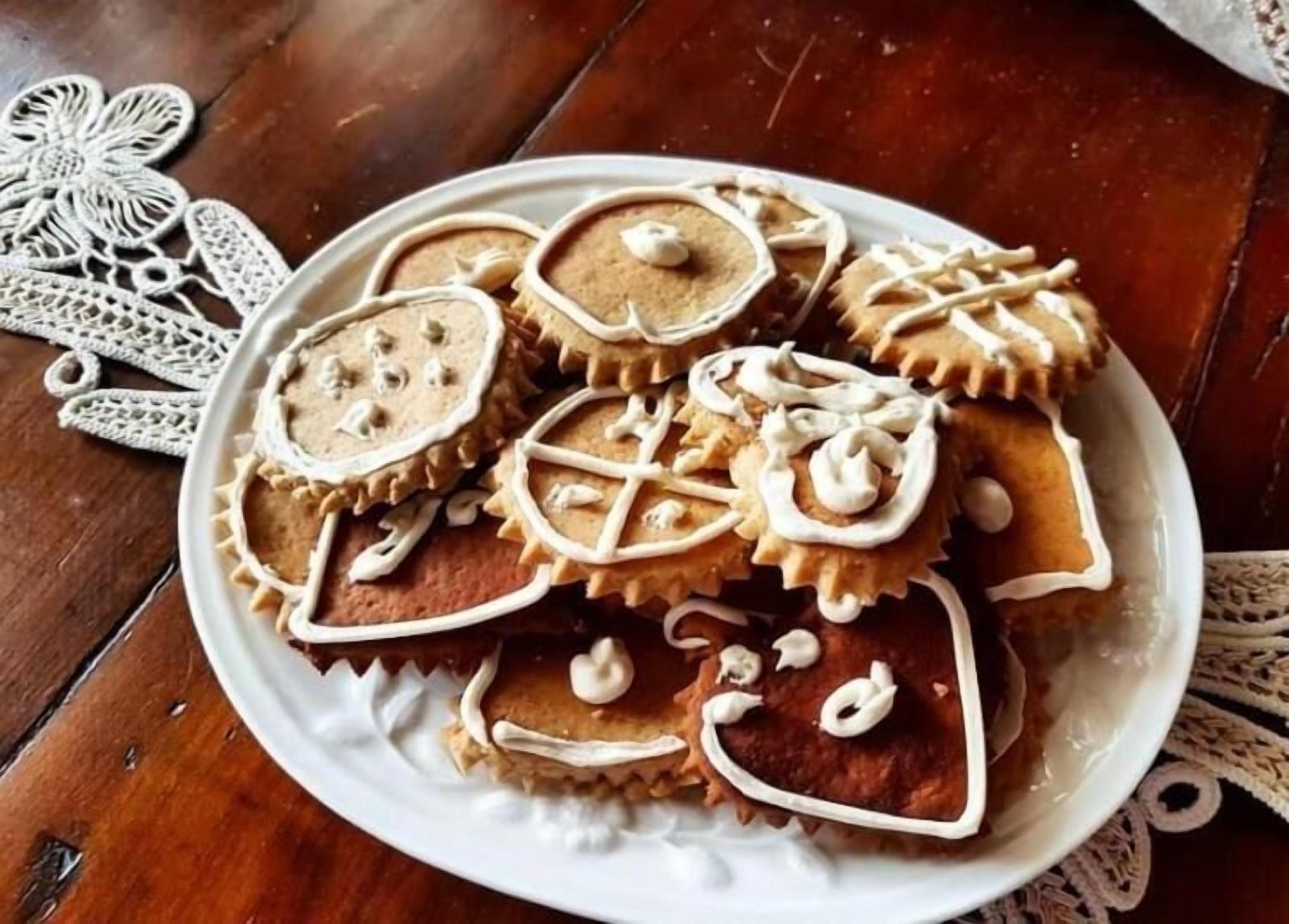 A plate of decorated cookies on a wooden table.
