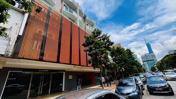A modern building with a distinctive facade featuring vertical wooden slats. - Cozy Hotel at KL Sentral (Kuala Lumpur)