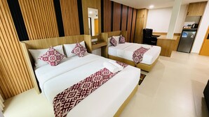 A hotel room with two beds, a wooden headboard, a desk, and a refrigerator. - Cozy Hotel at KL Sentral (Kuala Lumpur)