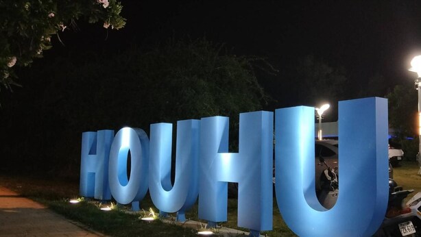 Large illuminated letters spelling "HOUJU" at night. - O Share Sweet B&B (Jinning)