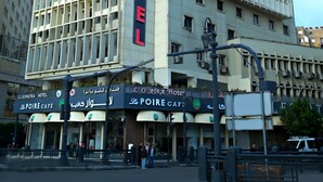Ett högt hotell med en fasad som liknar ett rutmönster och en tydlig skylt med texten ”CLEOPATRA HOTEL”.
