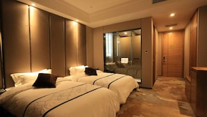 Une chambre d’hôtel avec deux lits, une douche en verre et une armoire en bois.