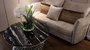 Une table ronde en marbre noir, sur laquelle sont posés un pot de fleurs et des fleurs blanches.