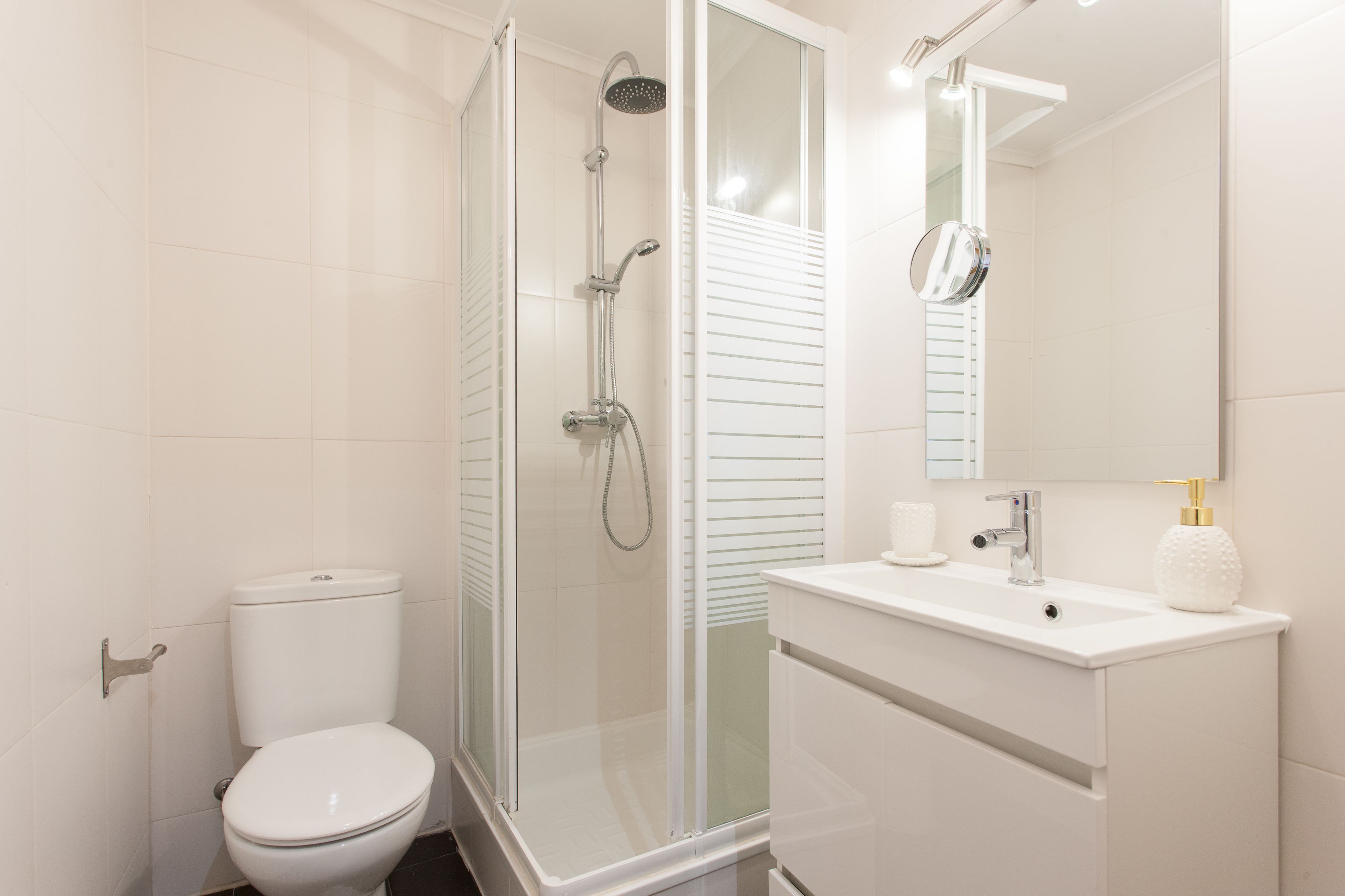 Studio (2.º Esq) | Badkamer | Een douche, een haardroger, handdoeken, toiletpapier